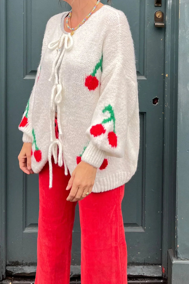 Cardigan femme en tricot avec nœuds décoratifs et broderies cerises scintillantes. Douillet et tendance.