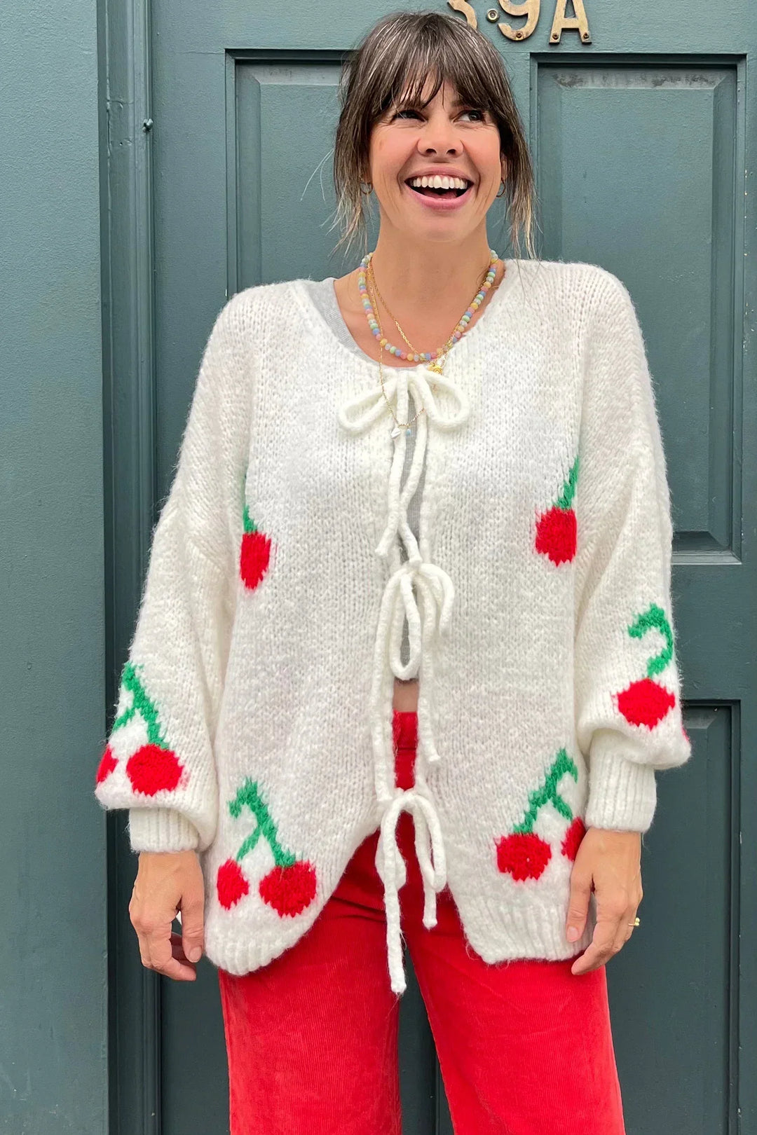 Cardigan femme douillet, tricot fin, nœuds élégants & cerises étincelantes. Parfait pour la mode automnale chic.
