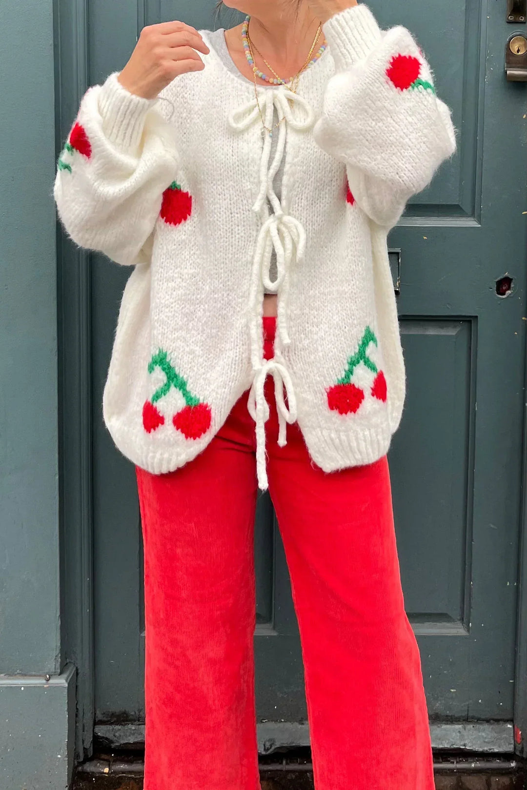 Cardigan femme en tricot, nœuds délicats, cerises scintillantes. Style chic & douillet pour l'automne.
