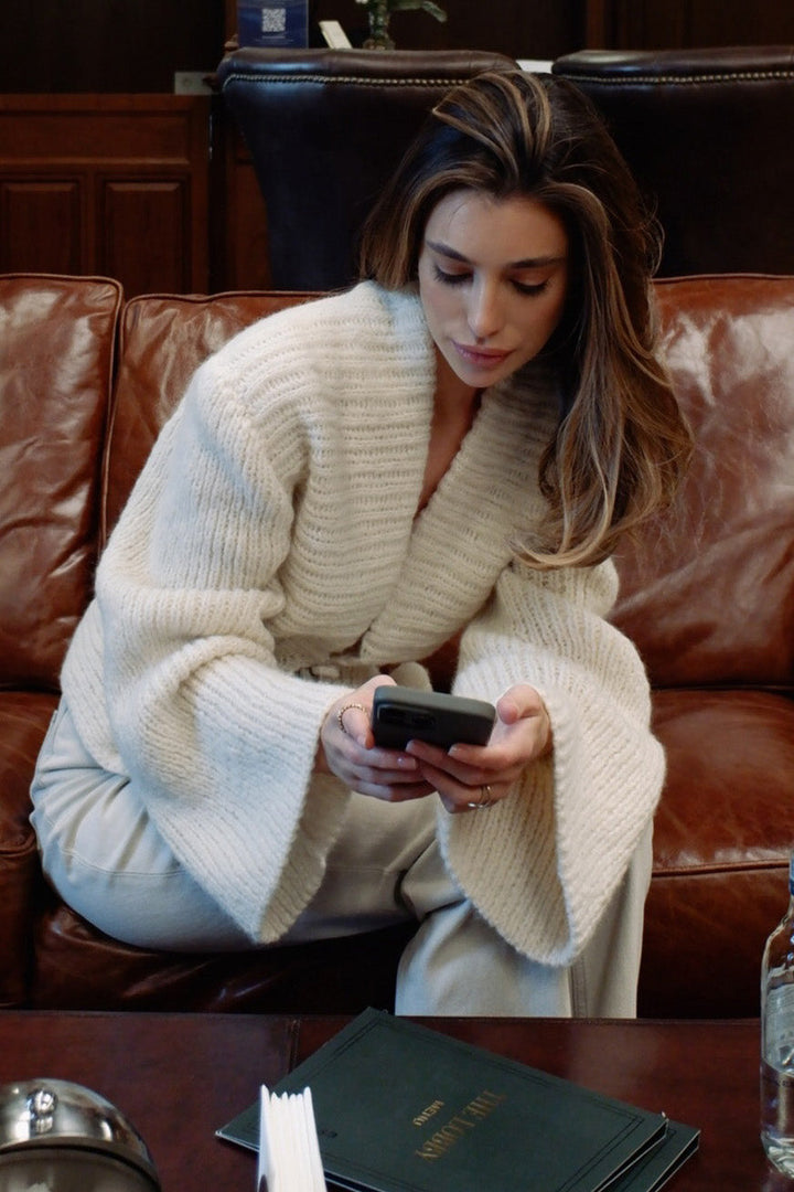 Cardigan d'automne blanc pour femme, style chic décontracté avec manches larges et fermeture boutonnée.