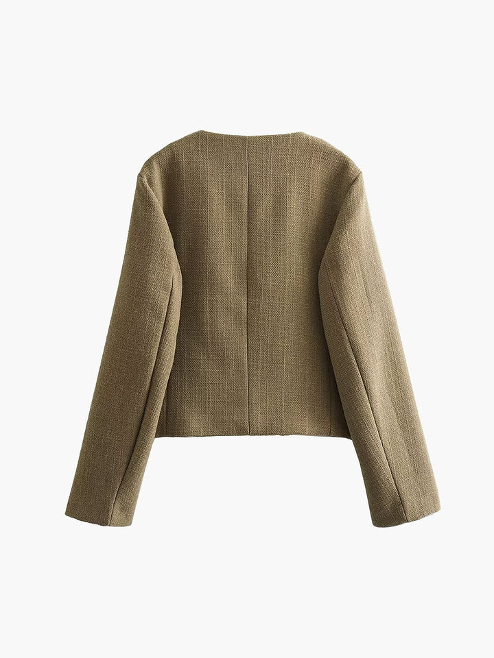 Veste courte femme, boutons dorés. Style tailleur élégant, col rond. Tendance mode féminine pour saison fraîche.