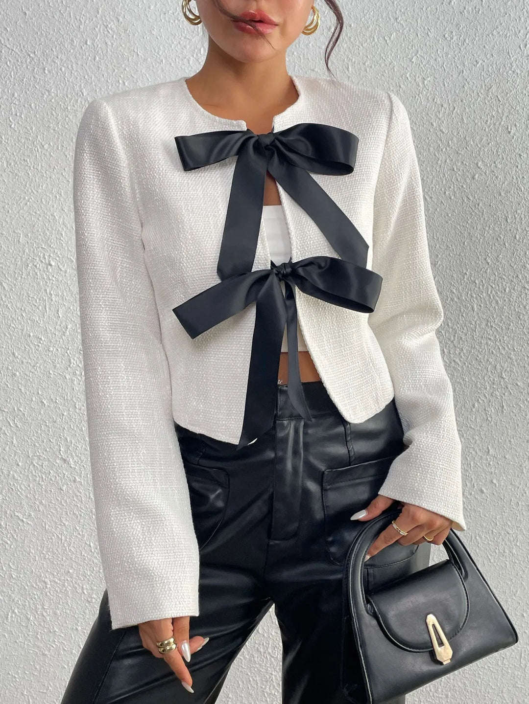 Veste chic femme courte, idéale pour le bureau ou événements, avec nœuds décoratifs, mode raffinée.