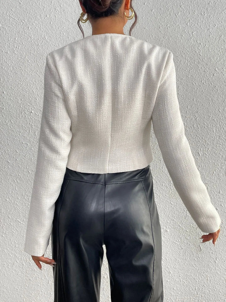 Veste féminine élégante, coupe courte moderne, ornée de nœuds sophistiqués, parfaite pour un look printanier.