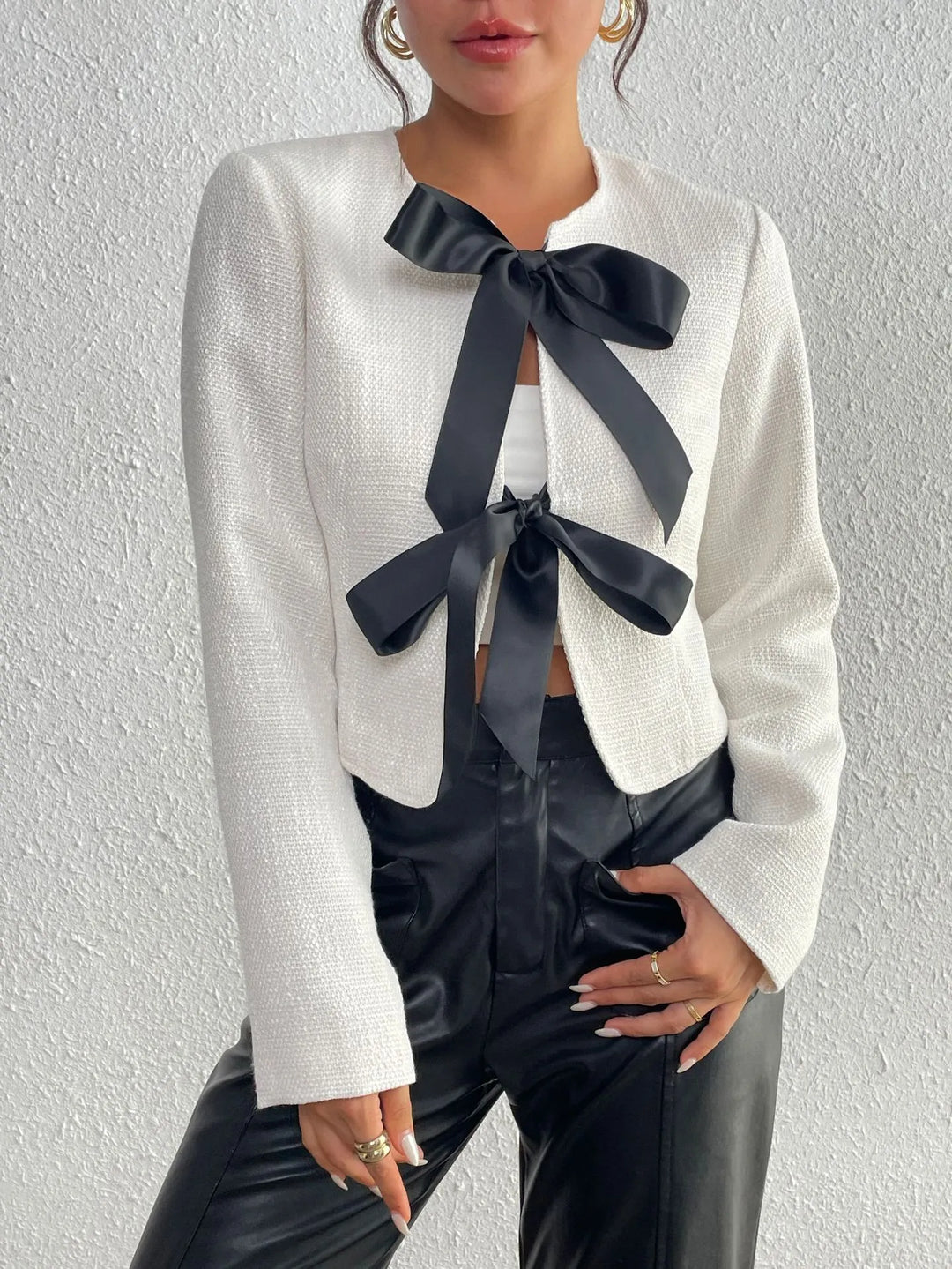 Veste de bureau chic pour femme, coupe courte élégante avec nœuds distinctifs, pour un look moderne et soigné.