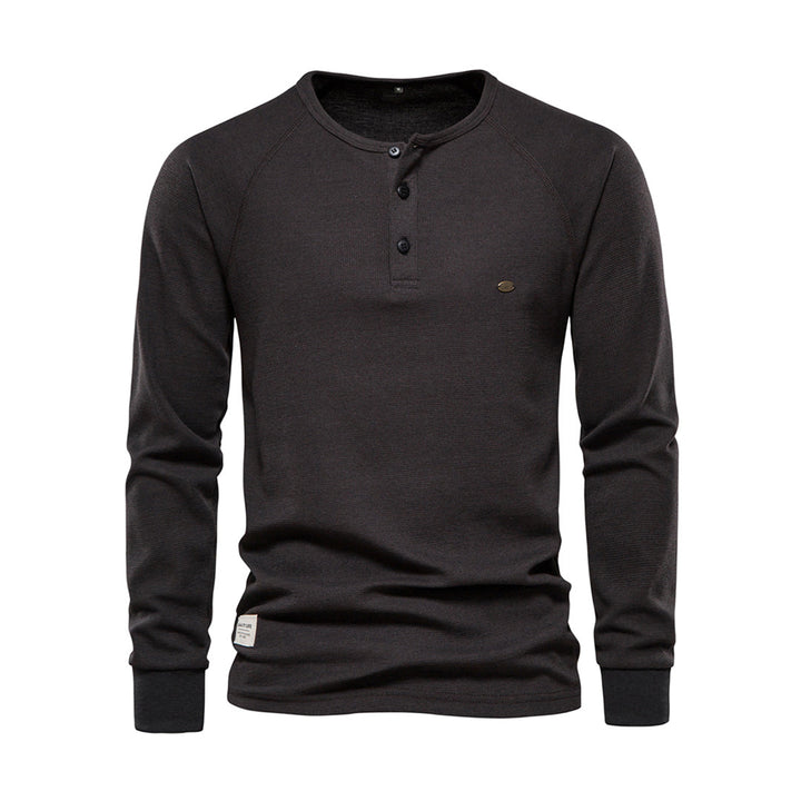 Gros plan sur les boutons et le col d'un t-shirt Henley homme à manches longues. Détail du vêtement casual.