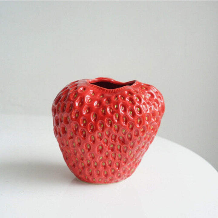 Design intérieur: vase fraise en céramique, texture palpable, accent original pour salle à manger.