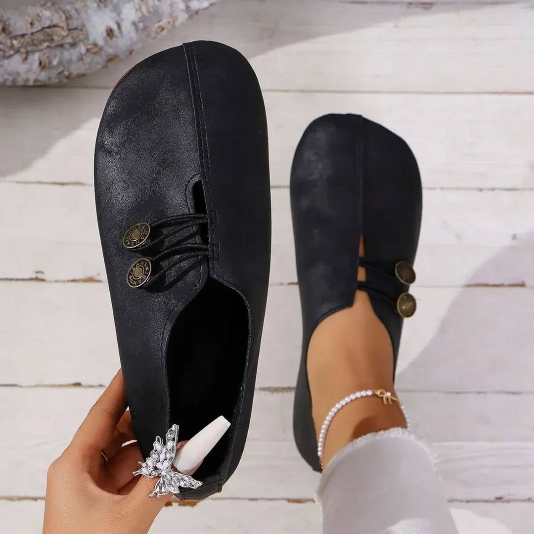 Femme portant chaussures plates élégantes, confort quotidien garanti. Style décontracté sans lacets pour printemps/été.