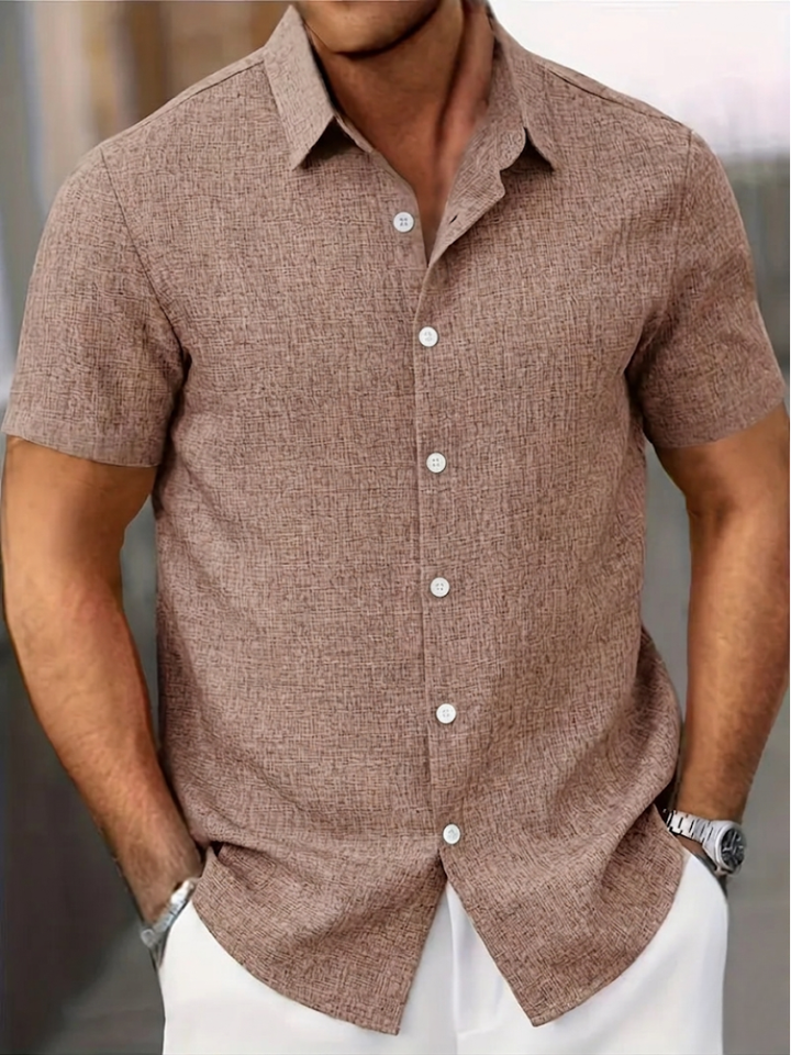 Homme portant une chemise à manches courtes confortable, style casual chic pour la saison estivale.