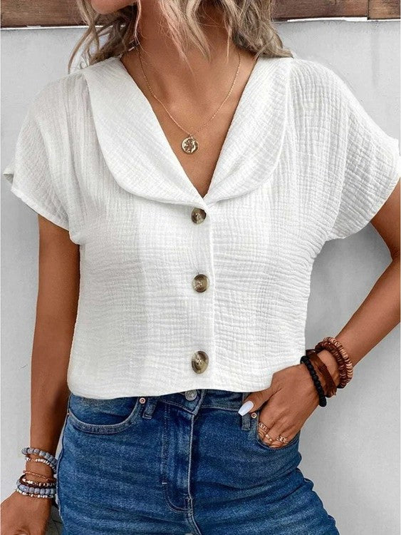 Chemise femme style chic, texturée, avec jolis boutons décoratifs pour un look moderne et tendance.