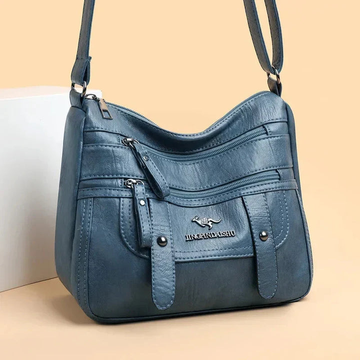 Sac bandoulière femme rouge vif en cuir, un accessoire chic pour compléter votre look élégant.