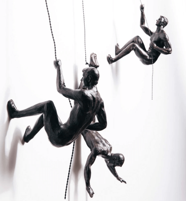 Art mural moderne : homme en résine escaladant, une pièce inspirante pour votre intérieur.