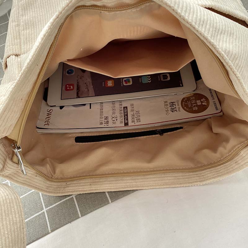 Sac bandoulière rétro pour femme en velours côtelé marron, avec poches intérieures et extérieures.