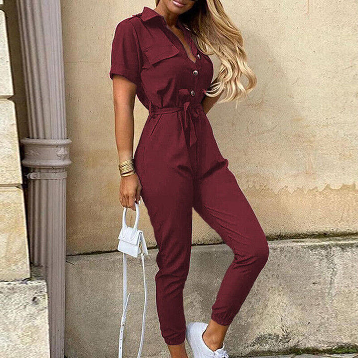 Jumpsuit femme noire cintrée, manches courtes, ceinturée, style chic décontracté, idéale pour la mode d'été.