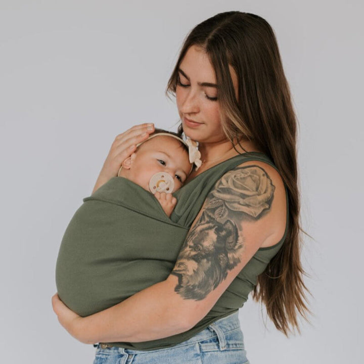 Parent souriant portant son bébé dans un porte-bébé T-Shirt pratique et ergonomique, mains libres.