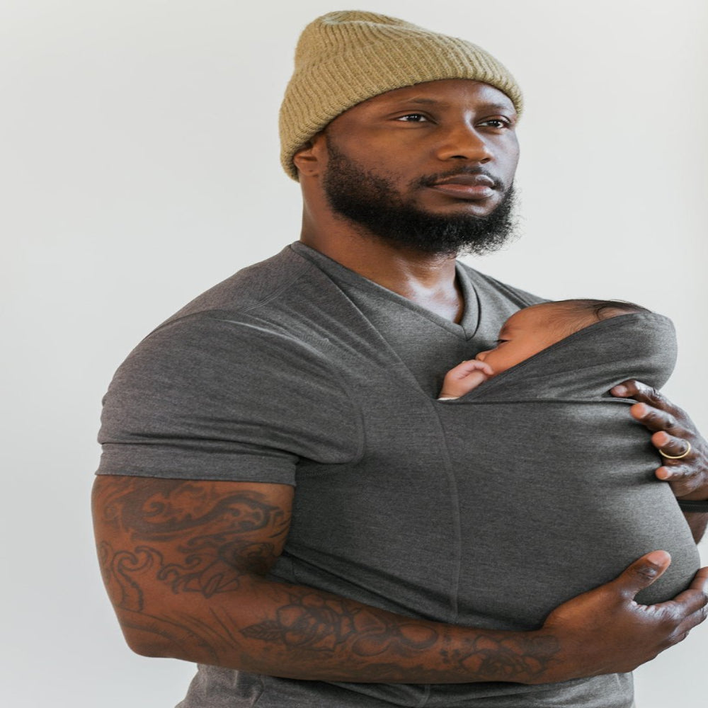 Gros plan sur un bébé paisiblement porté dans le porte-bébé T-Shirt, offrant un soutien doux.