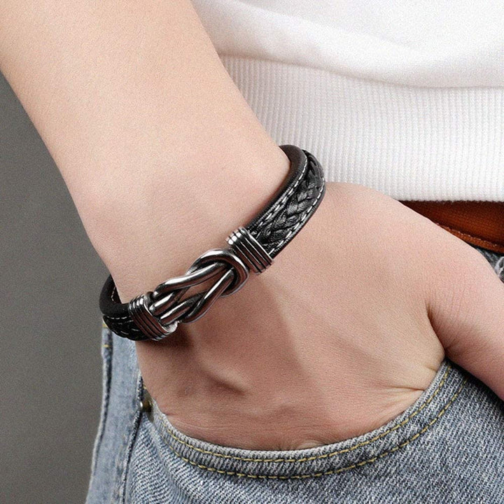 Bracelet noir unisexe, nœud infini, accessoire intemporel qui complète chaque tenue.