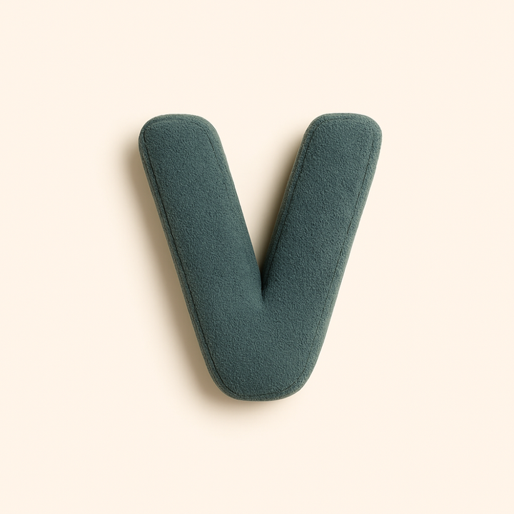 Coussin initiale V en coton, personnalisable, parfait pour lit enfant ou salon.