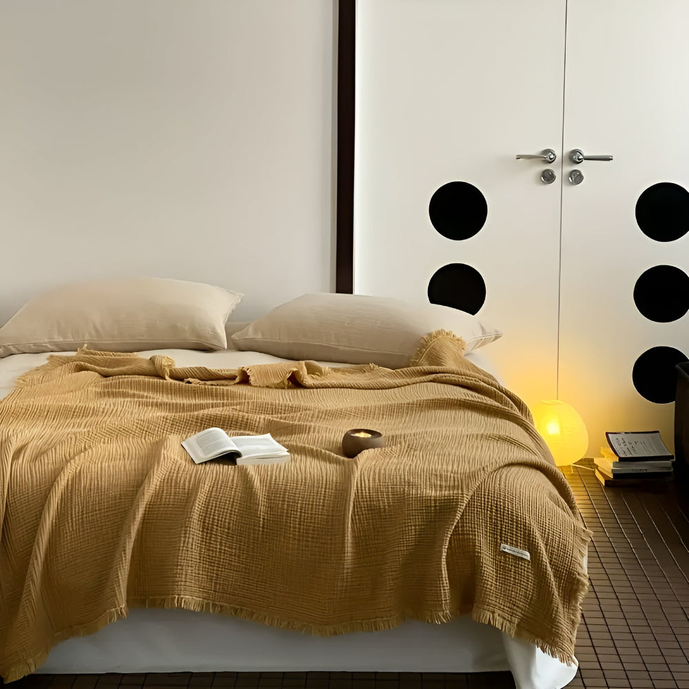 Détail du plaid gaufré en coton, doux au toucher, avec ses franges élégantes pour une décoration cosy.