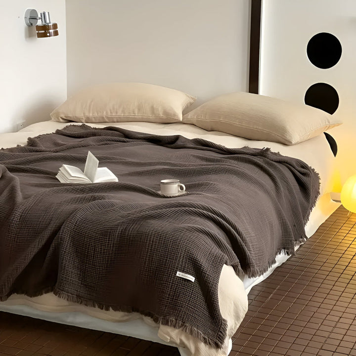 Plaid en coton doux avec motif gaufré et franges. Une pièce décorative et confortable pour la maison.
