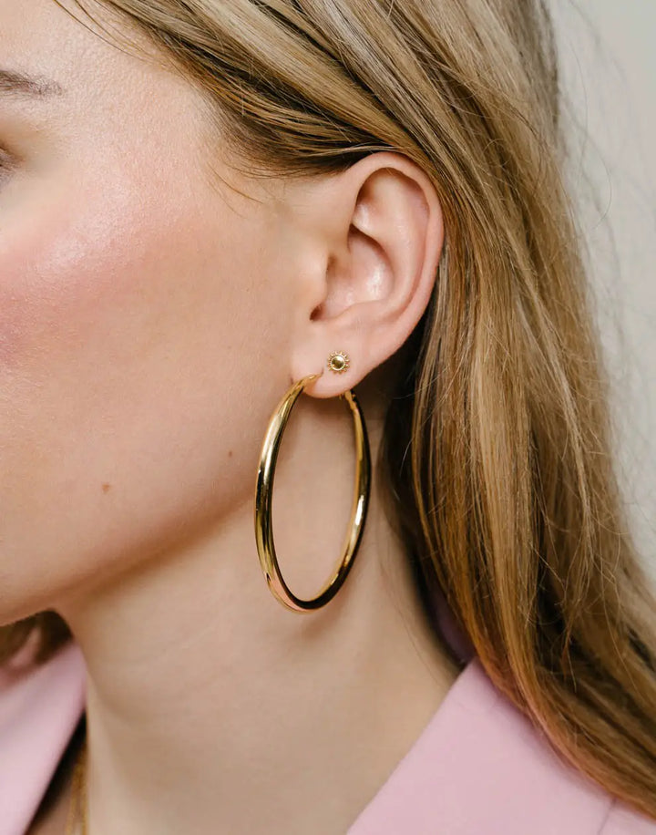 Grandes créoles dorées 60mm pour femme en acier inoxydable, un bijou élégant et tendance.