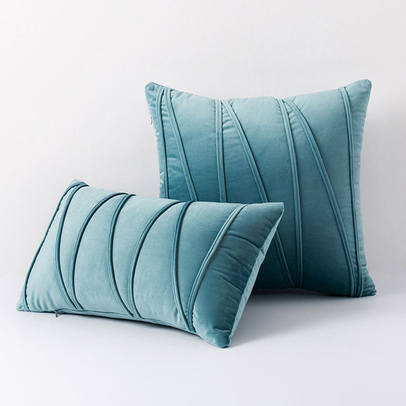 Vue rapprochée d'une housse de coussin plissée, mettant en valeur sa texture moderne et décorative.