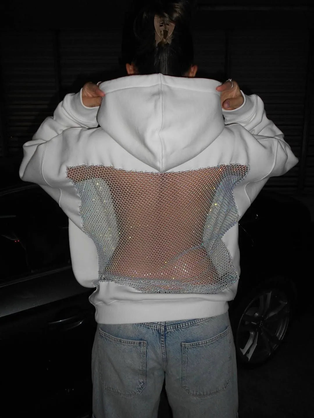 Sweat à capuche femme scintillant, brillant sous les lumières, idéal pour un style de soirée chic ou décontracté tendance.