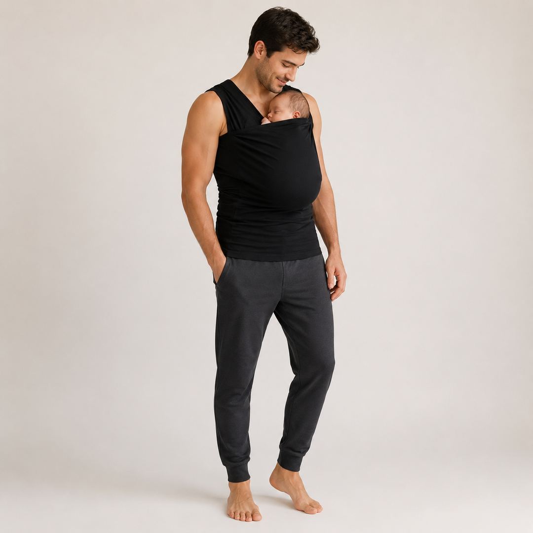 Parent cuisinant, mains libres, son bébé confortablement niché dans le t-shirt de portage.