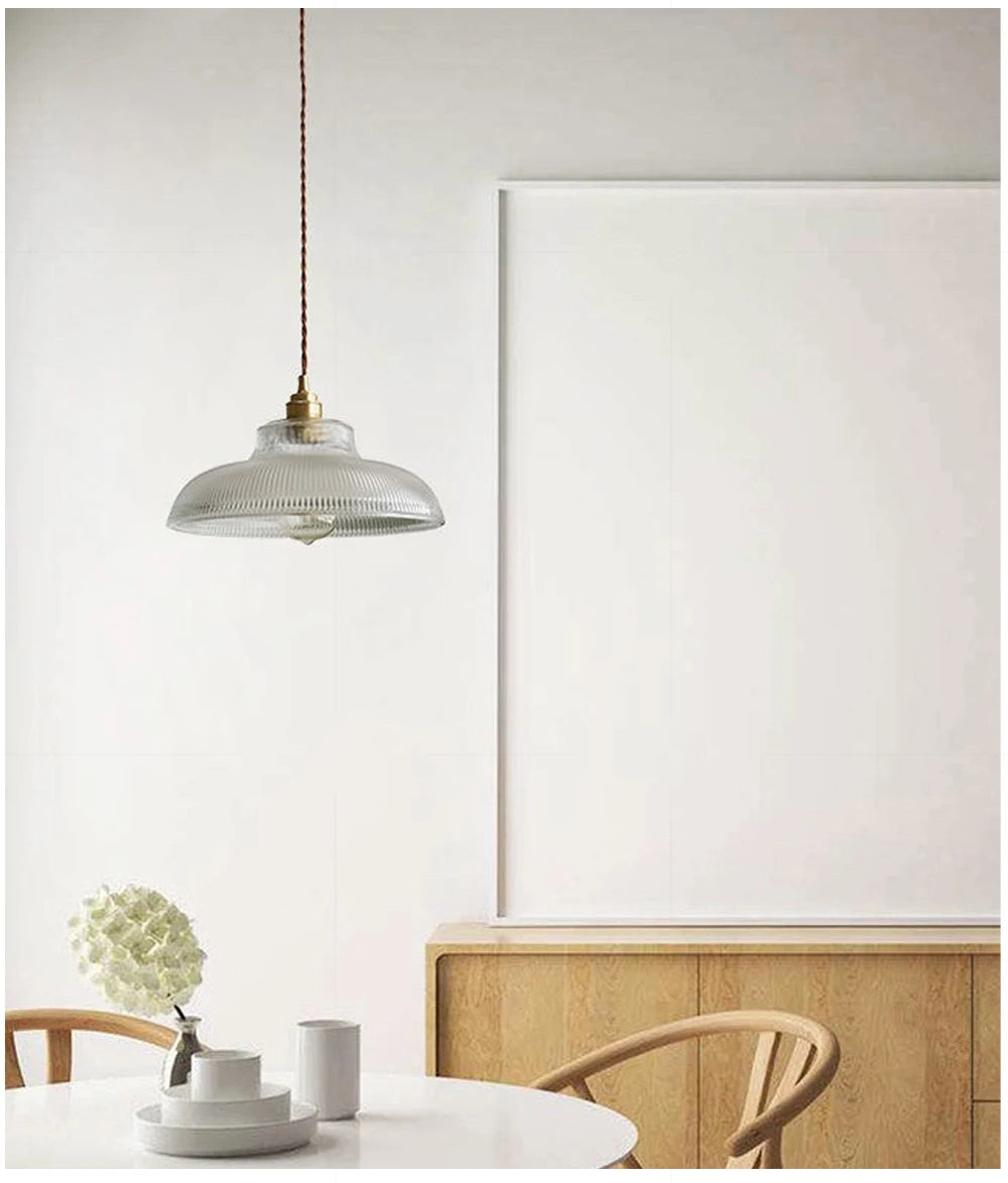 Lampe suspendue LED en verre au design moderne, éclairant un salon avec une lumière blanc chaud économique.