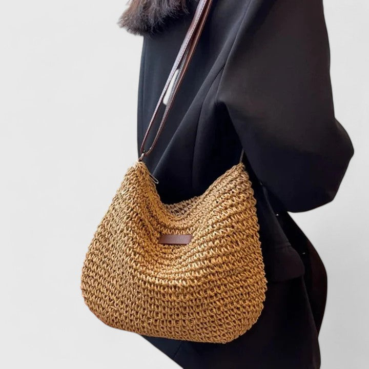 Élégant sac demi-lune en raphia naturel tressé pour femme, idéal accessoire mode estival.