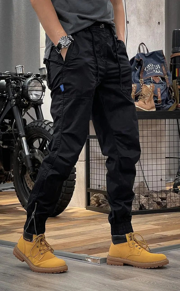 Homme de profil avec pantalon cargo slim kaki. Multi-poches pratiques et coupe tendance. Confortable et résistant.