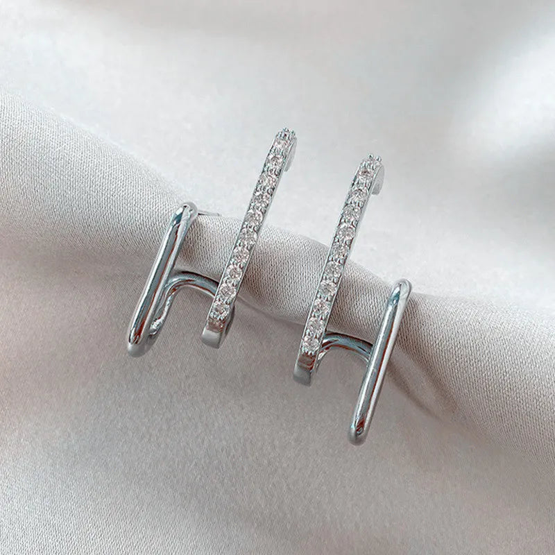 Boucles d'oreilles griffes en cristal argenté pour femmes, design chic et moderne.