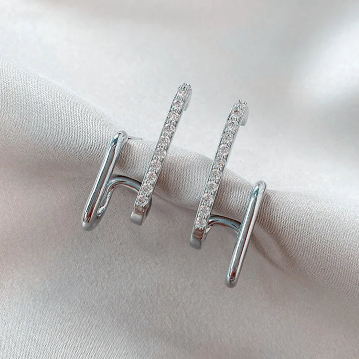 Boucles d'oreilles griffes en cristal argenté pour femmes, design chic et moderne.