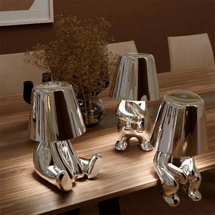 Lampe de table design moderne pour salon, ornement homme stylisé or, luminaire intérieur artistique LED.