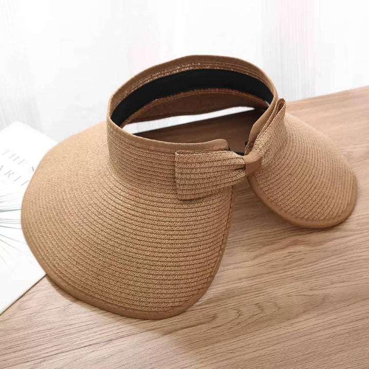 Chapeau visière femme pliable en paille naturelle avec large bord. Léger et pratique pour voyages estivaux.