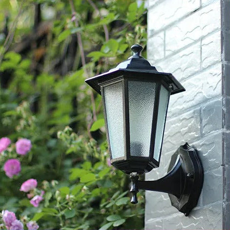 Lampe murale extérieure noire traditionnelle avec détecteur de mouvement pour un éclairage de jardin sécurisé.