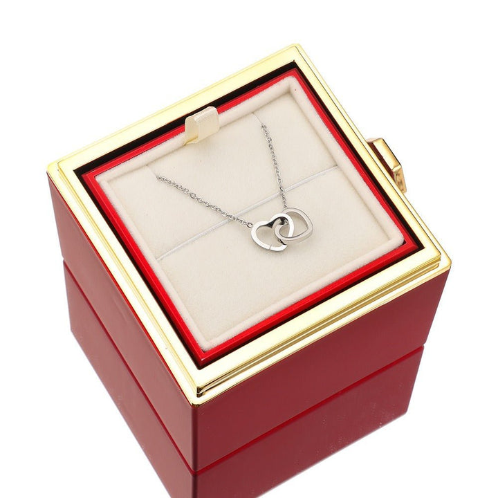 Magnifique rose éternelle rouge accompagnée d'un collier raffiné, symbole d'amour pur.