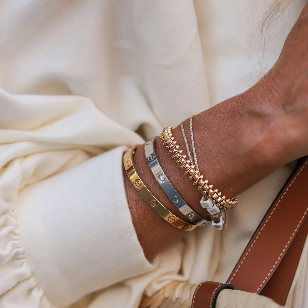 Gros plan bracelet jonc doré. Bijou femme chic, finition brillante, accessoire intemporel.
