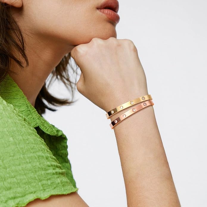 Bracelet jonc doré porté. Élégant au poignet d'une femme, accessoire mode intemporel pour un look raffiné.