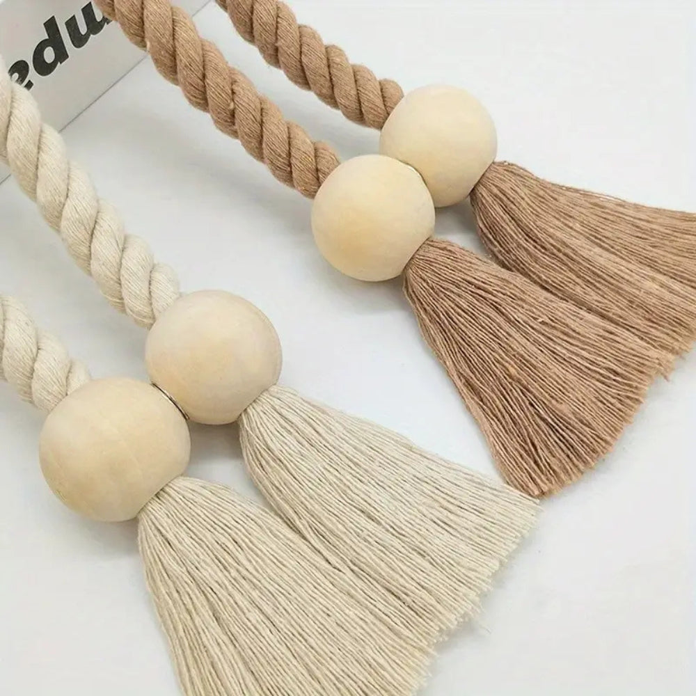 Détail d'une embrasse rideau en bois sculpté et pompons tissés, touche artisanale pour vos rideaux.