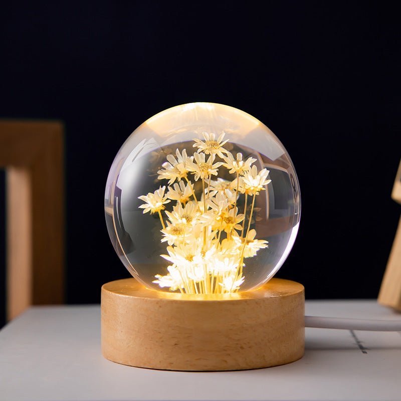 Lampe boule cristal et fleurs éternelles, base en bois de hêtre. Idéale pour une lumière d'ambiance douce et design intérieur.