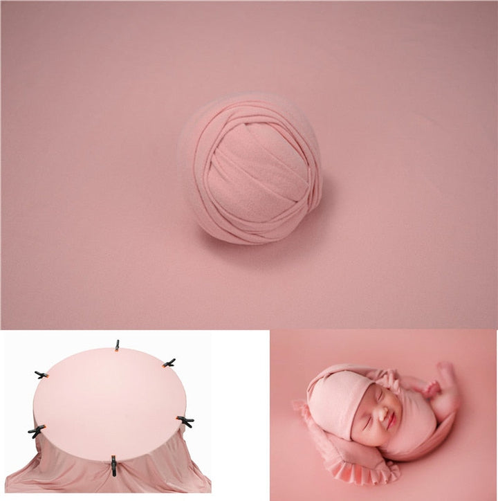 Accessoire de photographie bébé : mousseline délicate et toile de fond neutre.