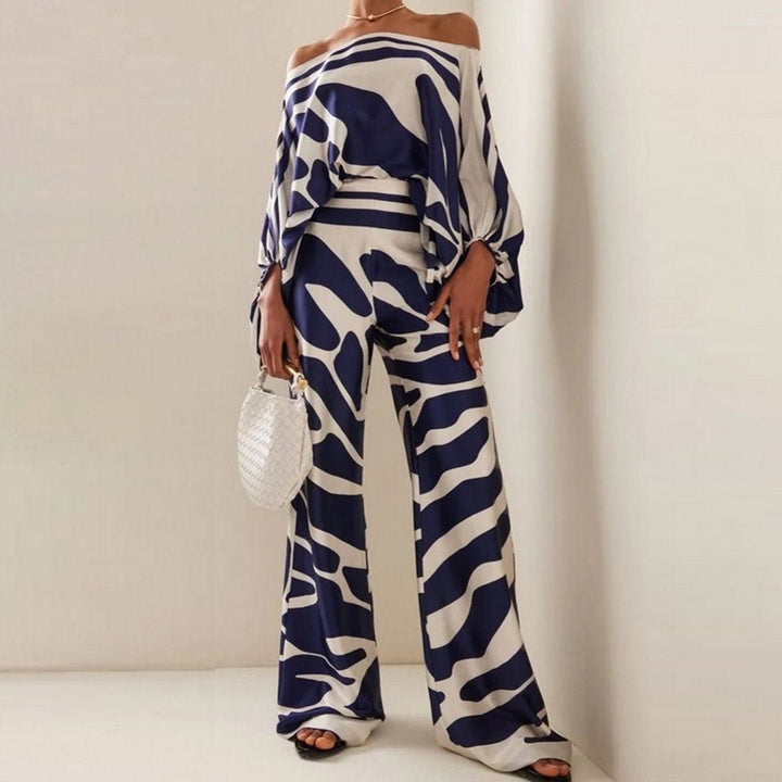 Silhouette fluide et élégante de l'ensemble deux-pièces femme, avec haut asymétrique et pantalon large tendance été.