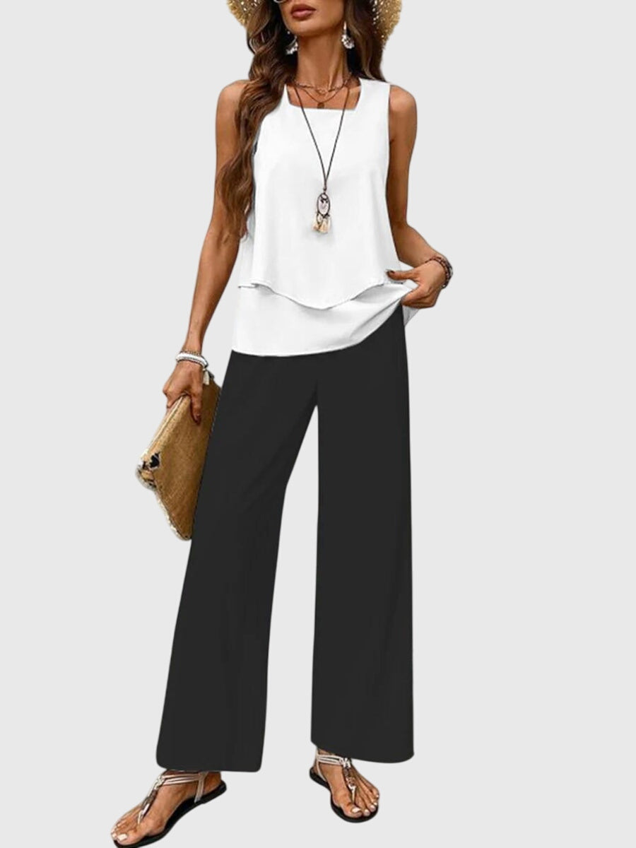 Femme portant un ensemble fluide décontracté floral, pantalon large et top élégant, idéal pour l'été et loisirs.