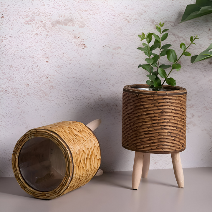 Jardinière tressée en rotin synthétique, design moderne sur pieds bois, idéale pour salon.