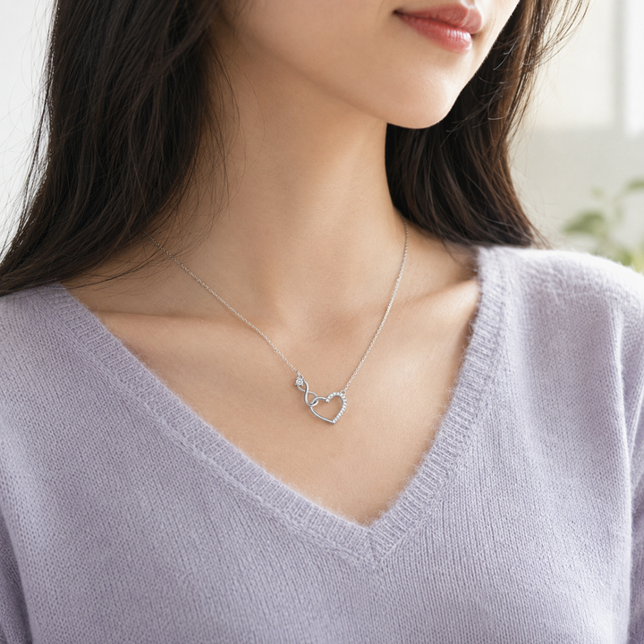 Collier pendentif cœur et bracelet pour femme, en argent et pierres zircone scintillantes.