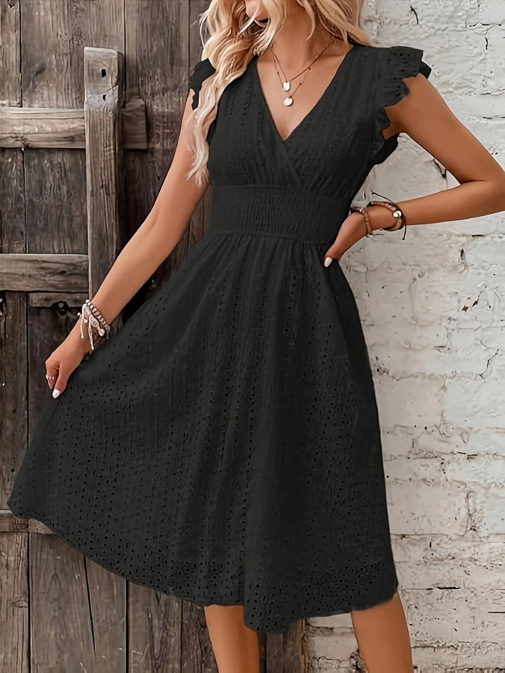 Silhouette d'une femme portant une robe portefeuille brodée, légère et confortable pour l'été.