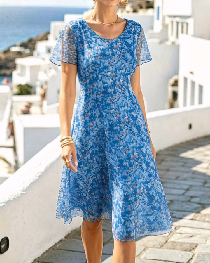 Robe florale féminine, coupe A classique, manches courtes, apportant fraîcheur et élégance estivale.