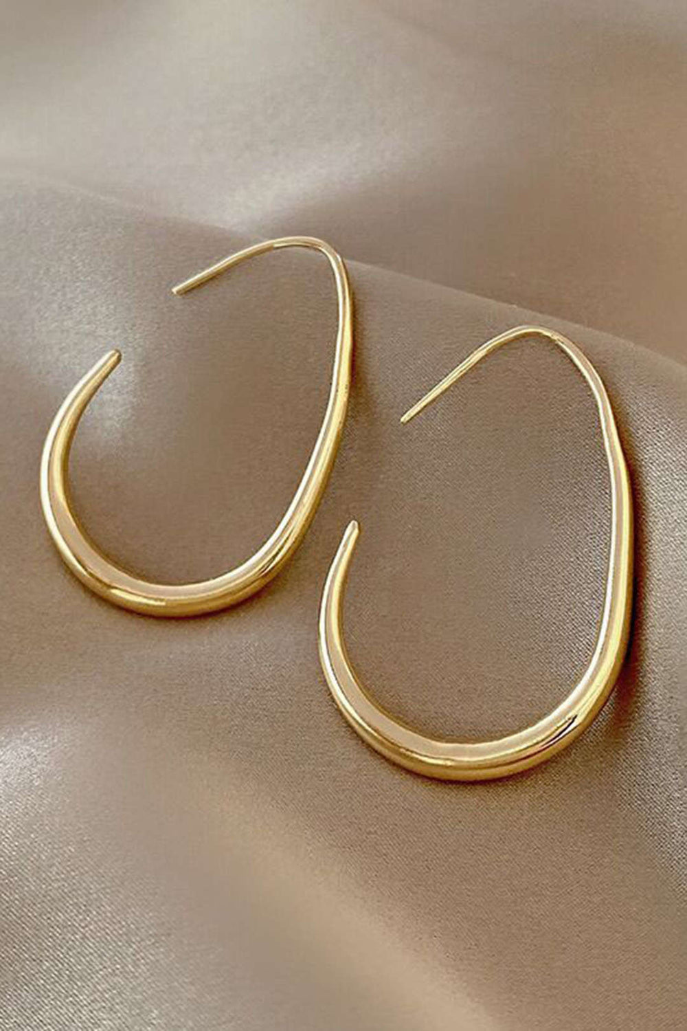 Paire de boucles d'oreilles ovales intemporelles en métal précieux, accessoire femme élégant et chic.