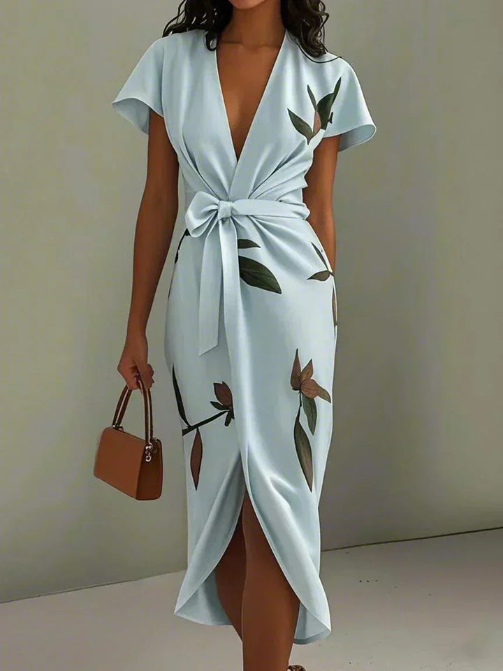 Robe midi chic femme avec motifs floraux vifs, coupe portefeuille flatteuse et manches courtes. Idéale pour l'été.
