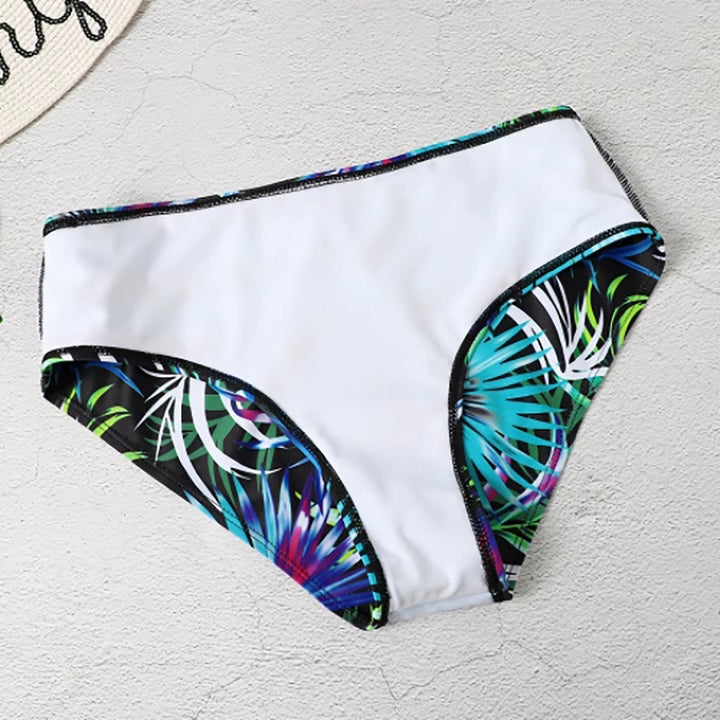 Femme portant un bikini taille haute à imprimé tropical sur une plage ensoleillée. Maillot de bain élégant d'été.